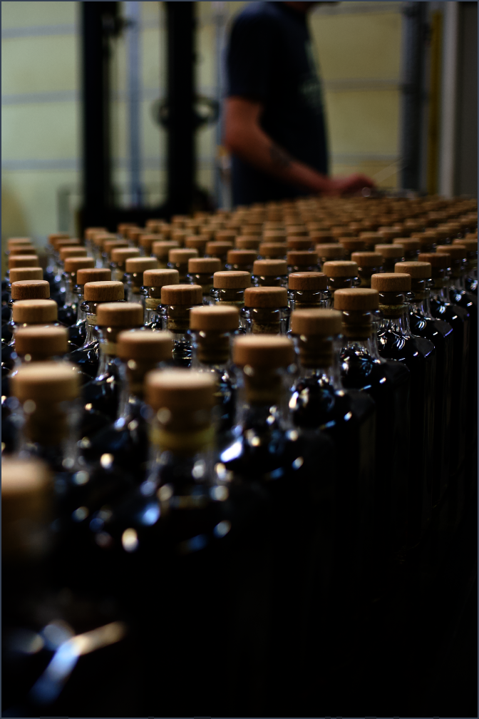 An artisan overseeing the bottling of a small batch of Luminance limited release bourbon, ready to fulfill its purpose.